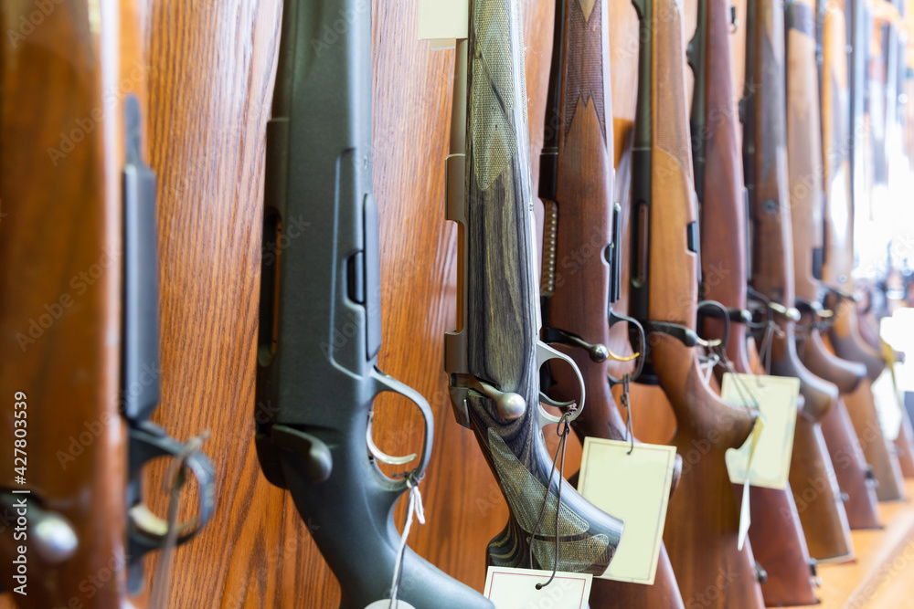 A tagged rifle on the slatwall, part of a catalogued inventory