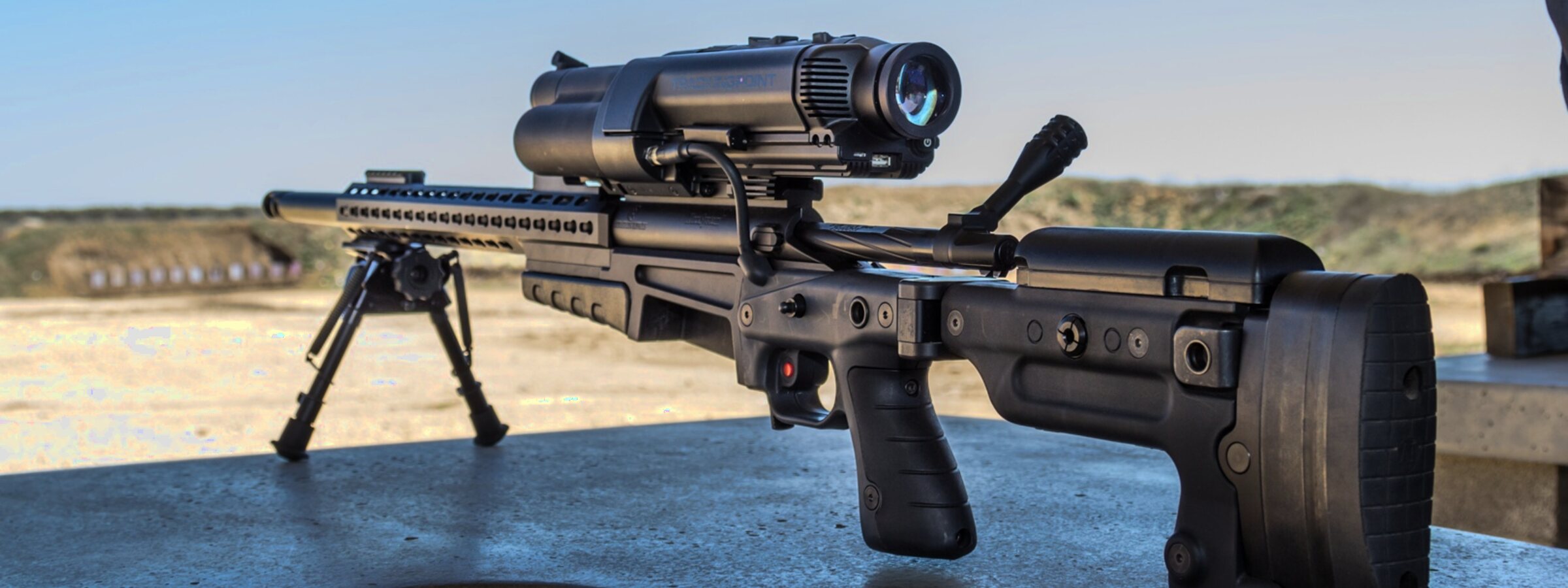 A rifle with an optic on a shooting range
